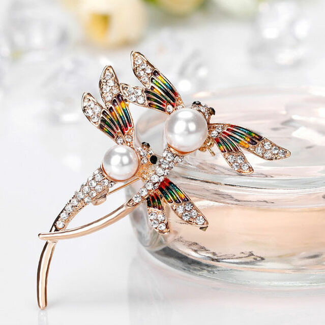 A sparkly brooch depicting two dragonflies